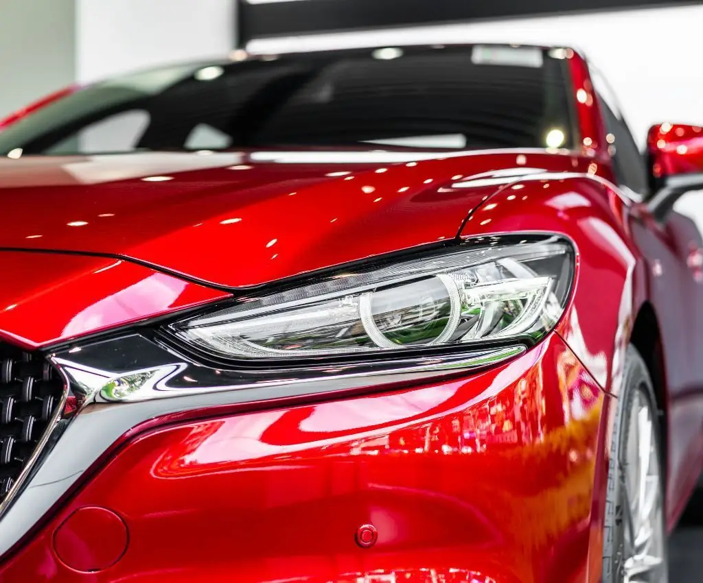 Close-up of a polished red front end and clear headlight