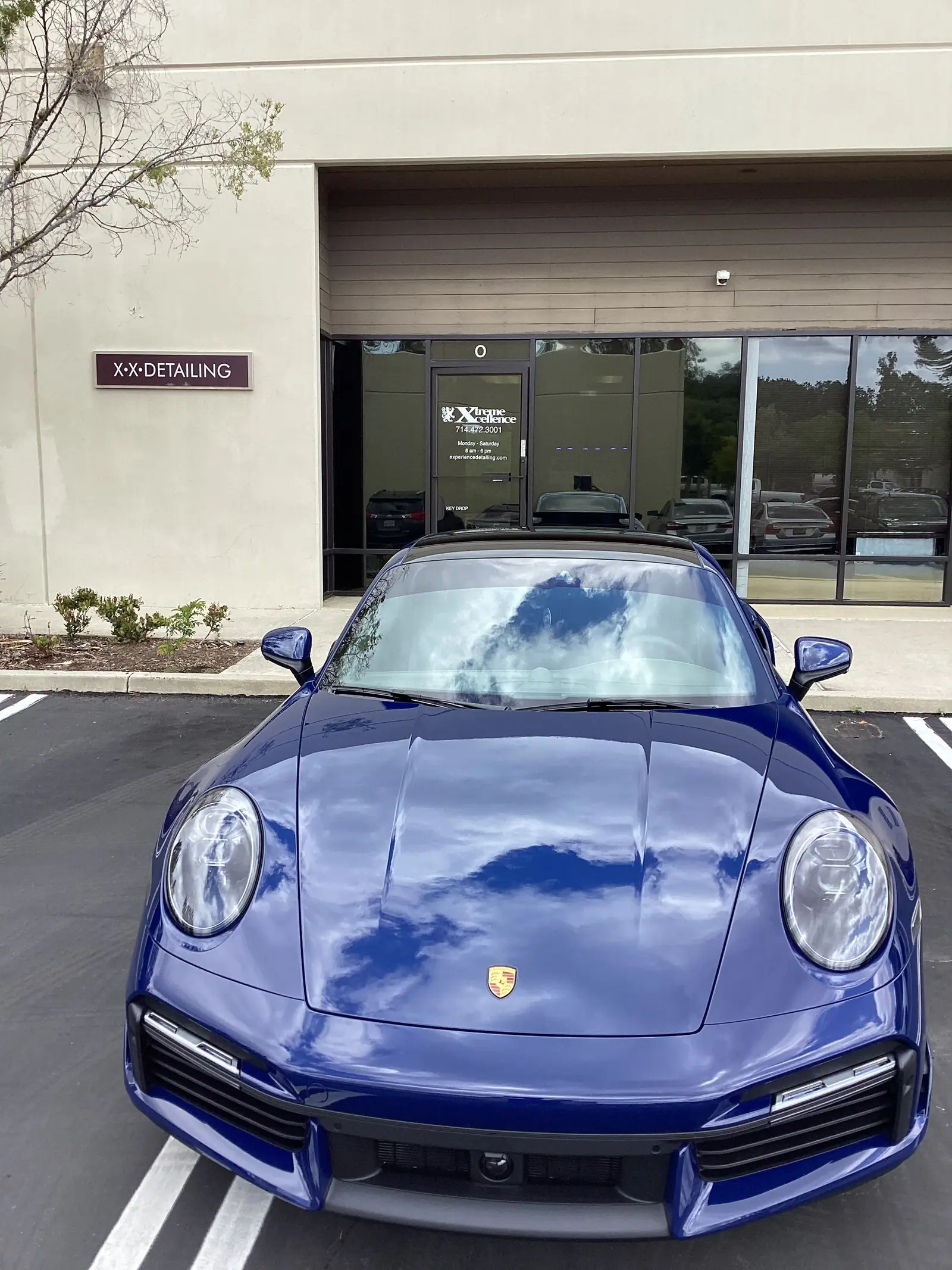 Blue Porsche 911 Turbo S parked outside the STRATA Detailing shop