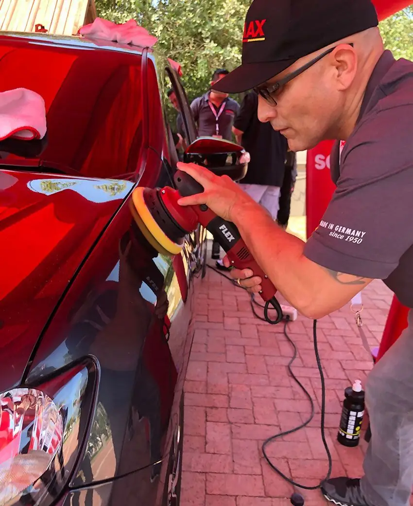 Detailer machine polishing a deep red panel with a FLEX polisher